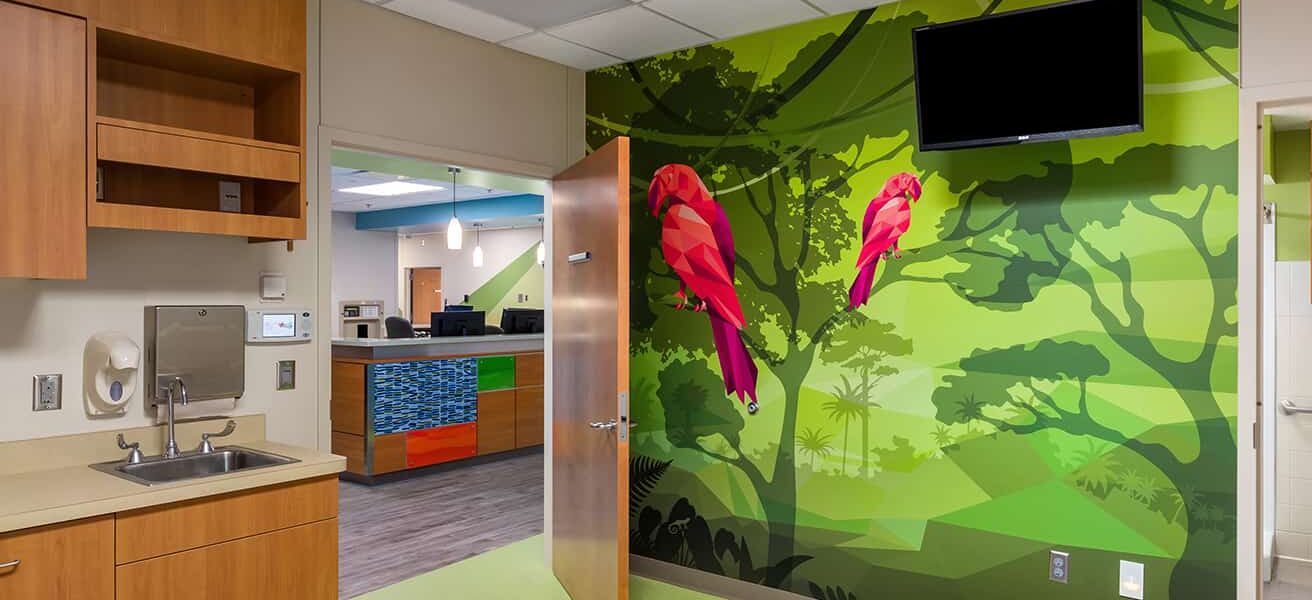 Footwall and view to the nurses station from a patient room featuring a parrot wall mural.