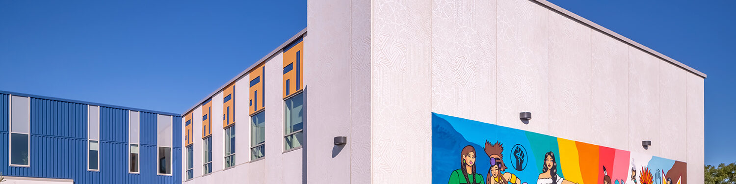 View to the side and back of the social services headquarters featuring a colorful neighborhood mural.